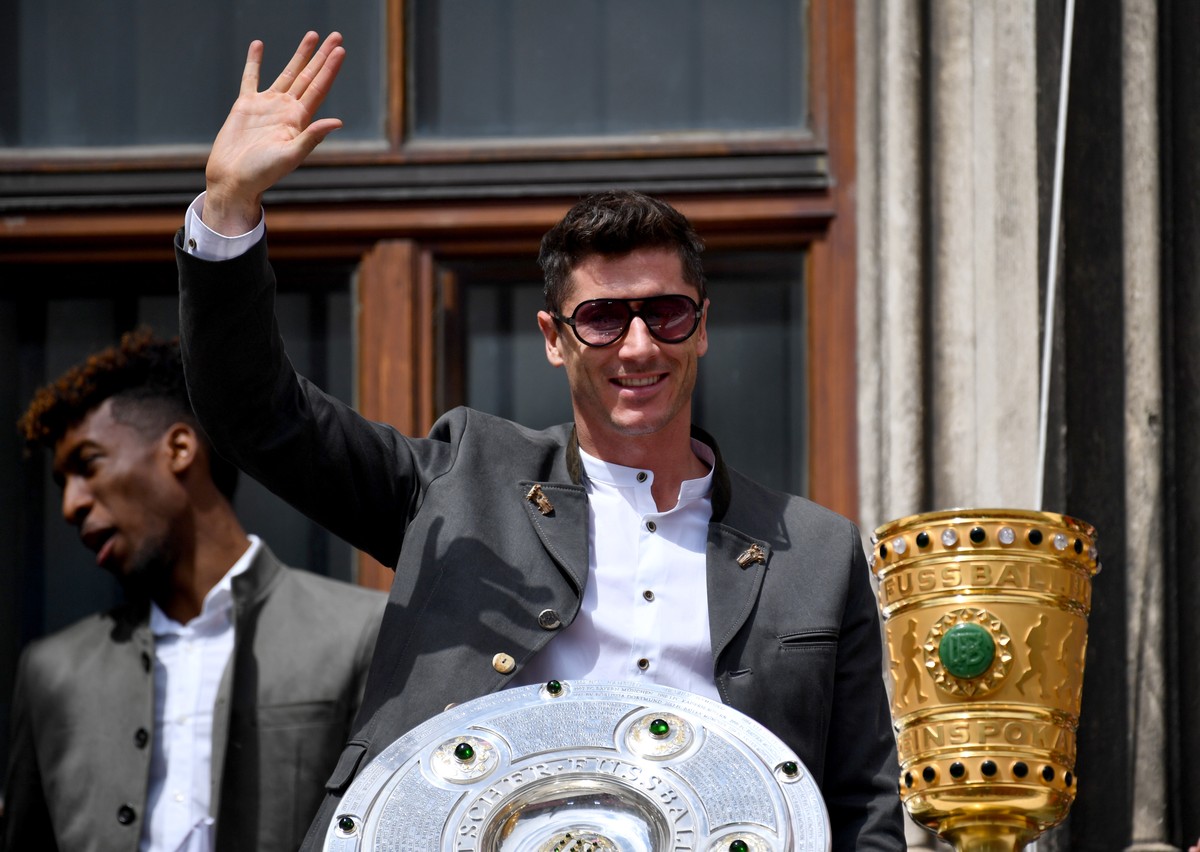 epa07602769 Bayern's Robert Lewandowski waves behind the German Bundesliga championship trophy and the the DFB Cup trophy during the celebration of FC Bayern Munich winning German championship an ...