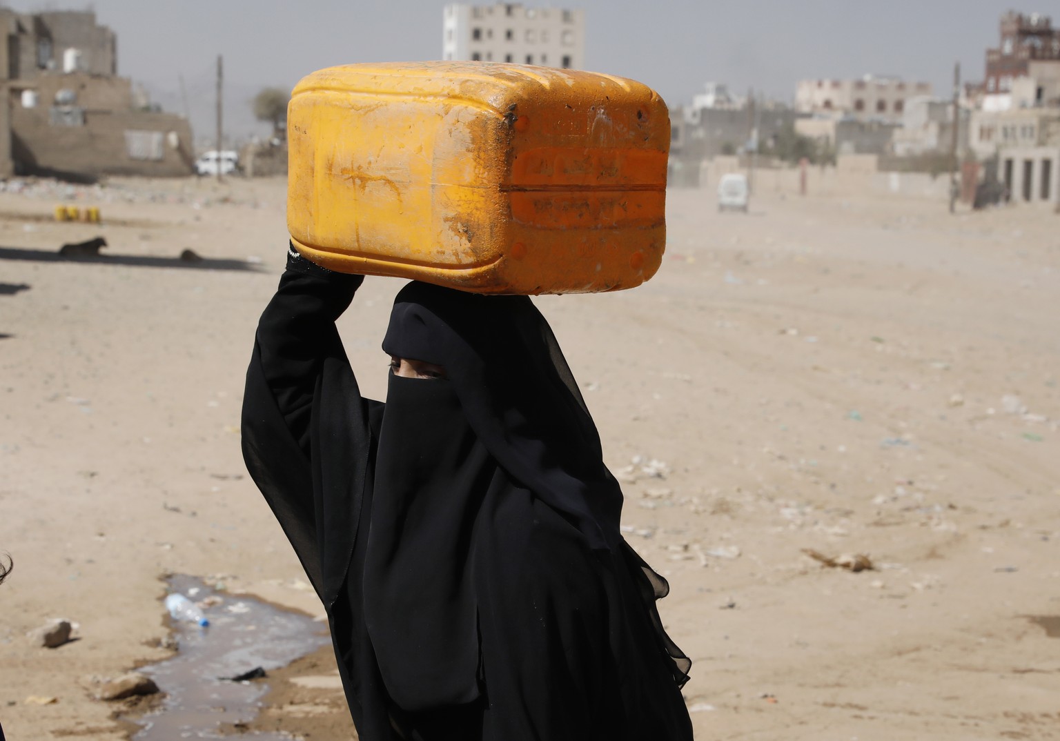 epa10325360 A Yemeni woman carries a water jerrycan after filling it from a donated tank amid a water shortage, on the outskirts of Sana&#039;a, Yemen, 24 November 2022. Yemen has one of the lowest pe ...