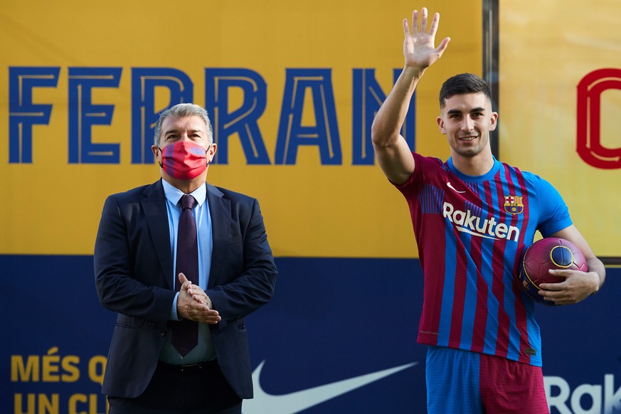 epa09664399 Spanish striker Ferran Torres (R) and FC Barcelona&#039;s President, Joan Laporta, during Torres&#039; presentation as new FC Barcelona&#039;s player at Camp Nou Stadium&#039;s pitch, in B ...