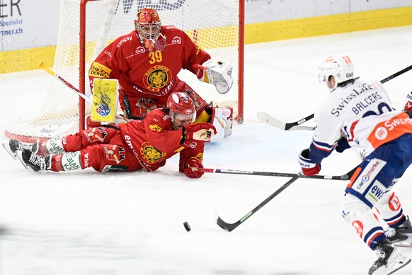 Tigers Goalie Luca Boltshauser, und Tigers Julian Schmutz, wehren sich gegen den Schuss von Lions Rudolfs Balcers, rechts, beim Eishockey-Qualifikationsspiel der National League, zwischen den SCL Tige ...