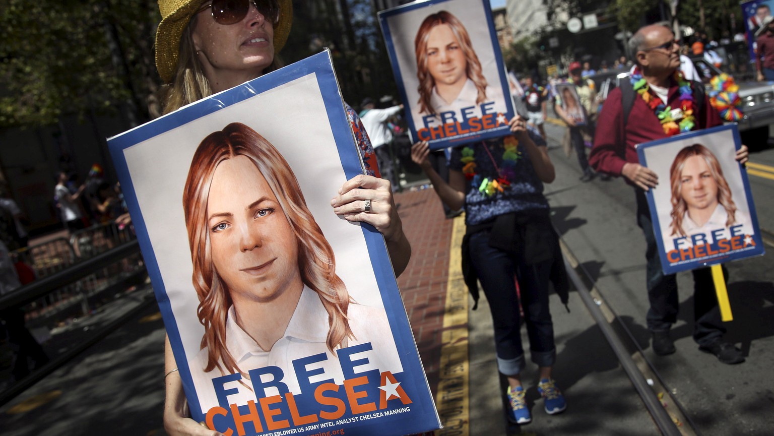 FILE PHOTO -- People hold signs calling for the release of imprisoned wikileaks whistleblower Chelsea Manning while marching in a gay pride parade in San Francisco, California June 28, 2015. REUTERS/E ...