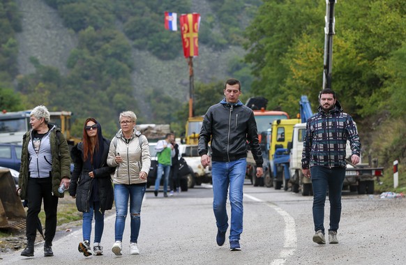Ethnic Serbs walk through barricades near the northern Kosovo border crossing of Jarinje on the ninth day of protest on Tuesday, Sept. 28, 2021. Ethnic Serbs in Kosovo have been blocking the border fo ...