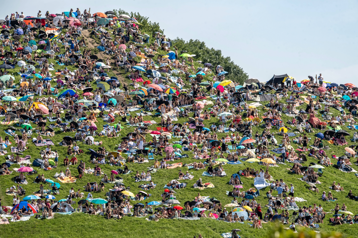 Taylor Swift Fans ohne Tickets hören sich das Konzert in München am 27. Juli 2024 auf dem Olympiaberg an.