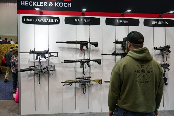 A guest browses firearms in the Heckler &amp; Koch display at the National Rifle Association&#039;s Annual Meetings &amp; Exhibits in Indianapolis, Sunday, April 16, 2023. (AP Photo/Michael Conroy)