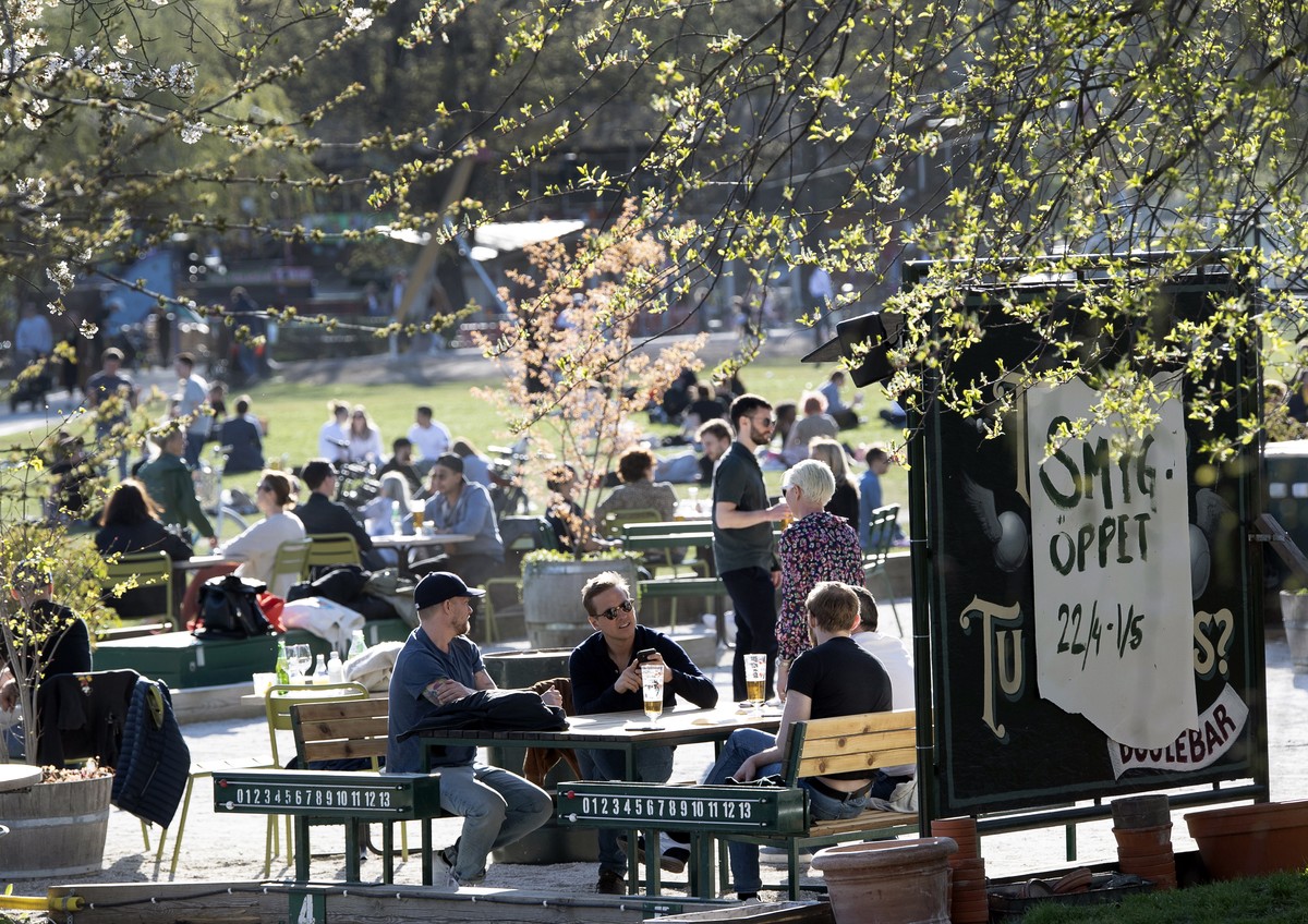 epa08378415 People gather in a cafe to enjoy the warm spring weather in Stockholm, Sweden, 22 April 2020, amid the ongoing coronavirus COVID-19 pandemic. Countries around the world are taking increase ...