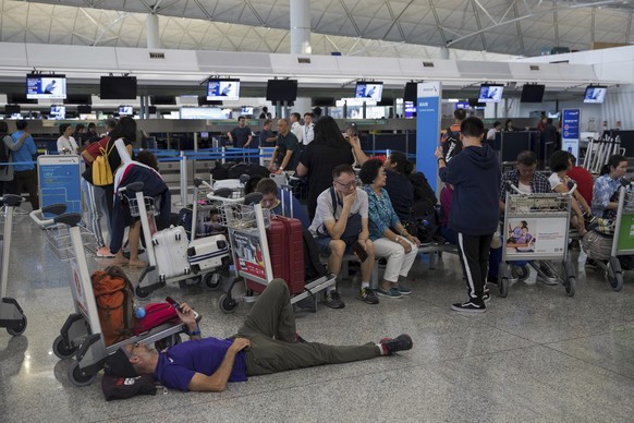 Stranded travelers wait in the departure hall of the Hong Kong International Airport in Hong Kong, Tuesday, Aug. 13, 2019. Protesters severely crippled operations at Hong Kong&#039;s international air ...