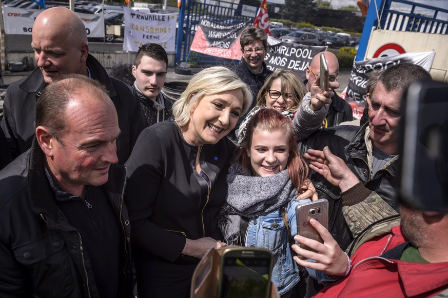 epa05928737 French presidential election candidate for the far-right Front National (FN) party, Marine Le Pen (C) poses for photographs with supporters and Whirlpool employees outside the Whirlpool pl ...