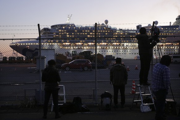 Videographers film the quarantined Diamond Princess cruise ship Thursday, Feb. 13, 2020, in Yokohama, near Tokyo. Life on board the luxury cruise ship, which has dozens of cases of a new virus, can in ...