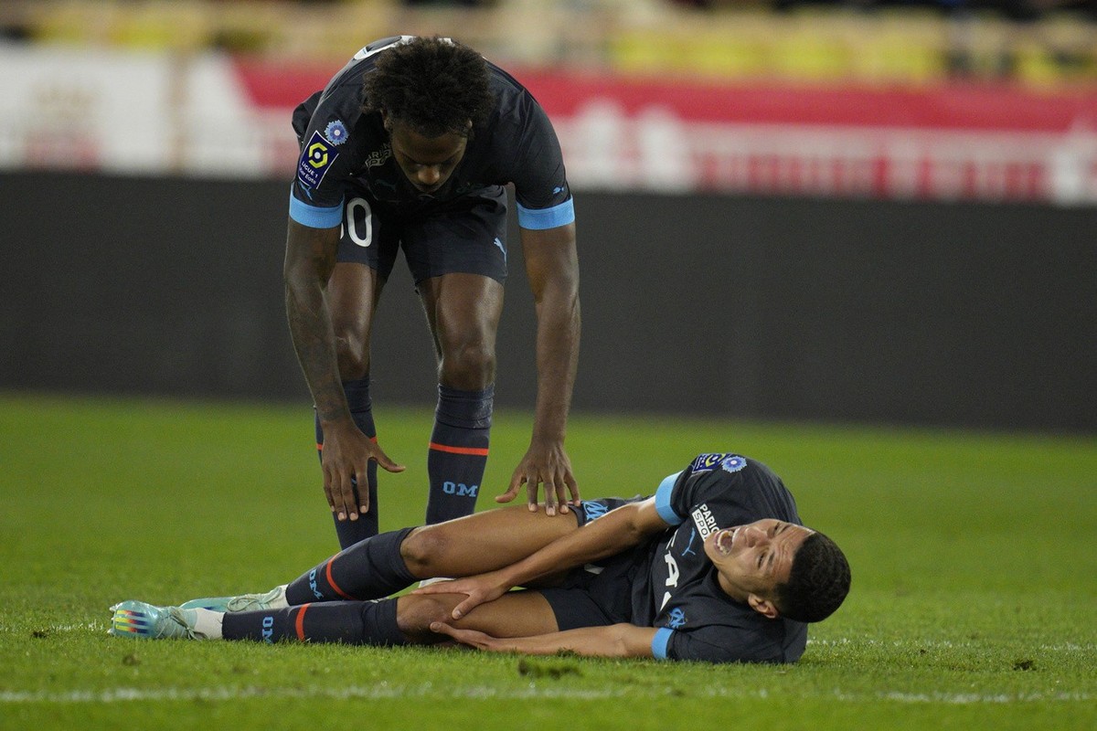 Marseille's Amine Harit lies on the pitch in pain during the French League One soccer match between Monaco and Marseille at the Stade Louis II in Monaco, Sunday, Nov. 13, 2022. (AP Photo/Daniel C ...