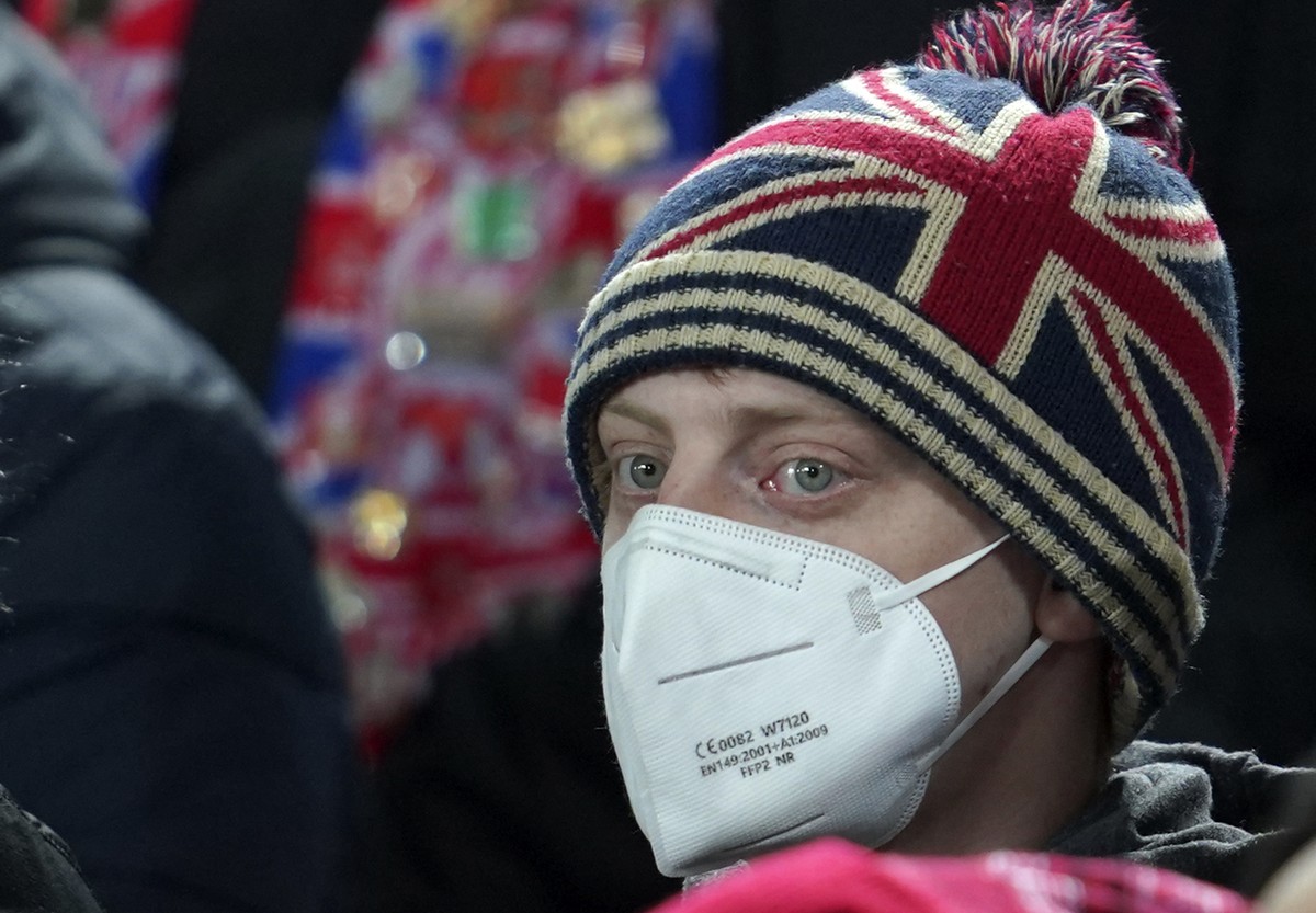 A fan wearing a face mask to protect against coronavirus looks out during the English Premier League soccer match between Liverpool and Newcastle United at Anfield stadium in Liverpool, England, Thurs ...