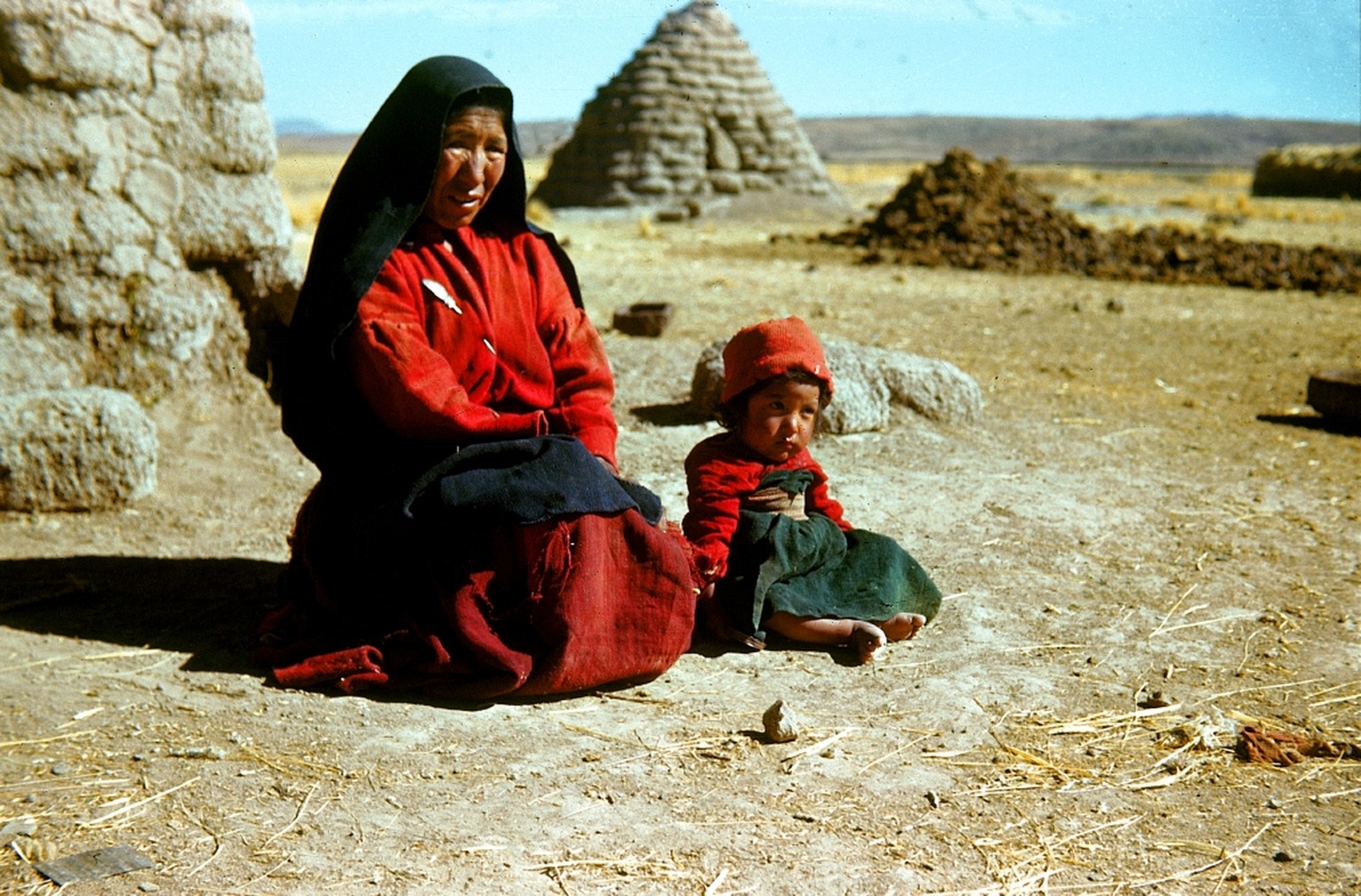 Eine Aimara-Indianerin mit Kind vor ihrer fensterlosen Adobe-Lehmhütte im südlichen Teil des Titicacasees bei Taraco in Bolivien, 1946.