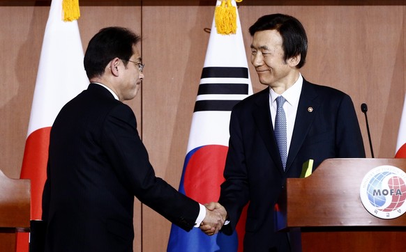 Der japanische Aussenminister Fumio Kishida (links) und sein südkoreanischer Kollege Yun Byung Se beim versöhnlichen Händedruck.&nbsp;