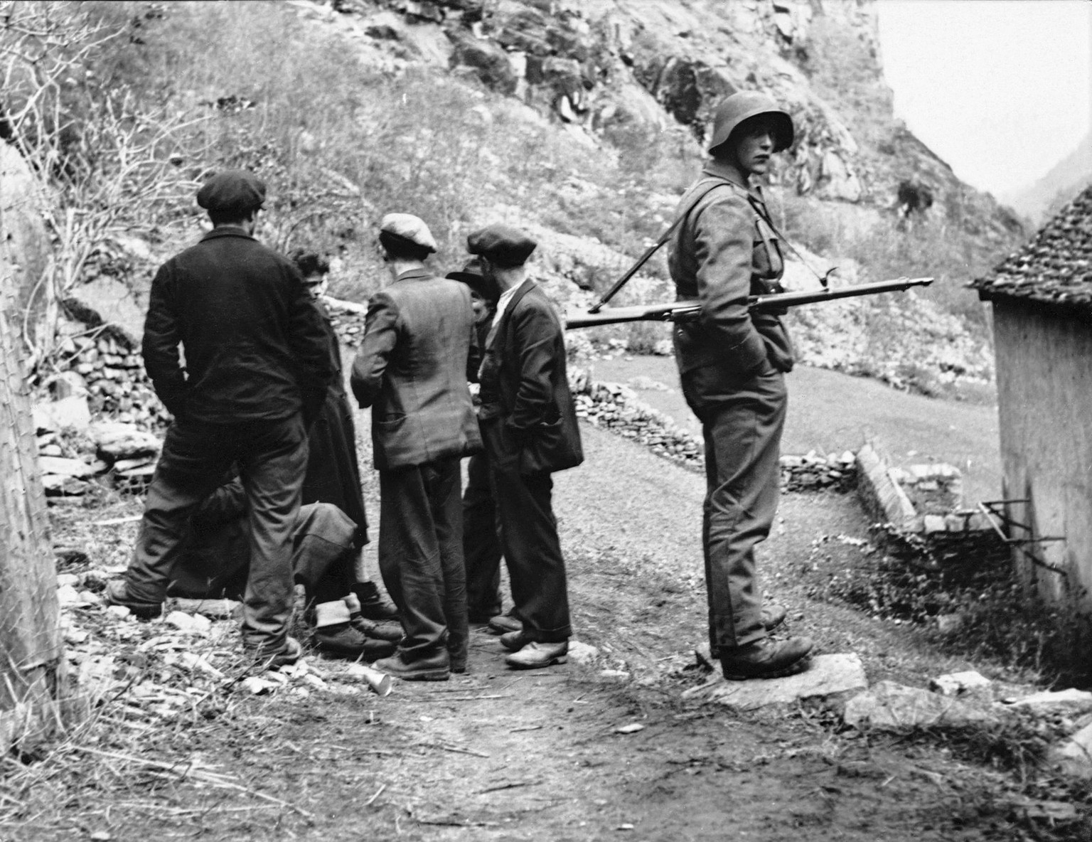 Ein Schweizer Grenzschützer schaut weg: Somit war die Grenze für Partisanen problemlos passierbar.
