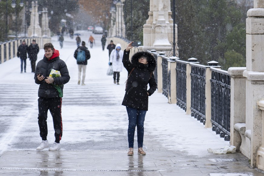 epa12628331 People walk on a street amid snow in Teruel, central Spain, 05 January 2026, due to Storm Francis. EPA/ANTONIO GARCIA