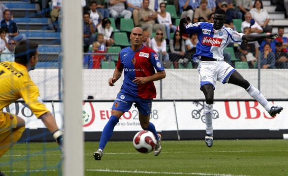 Der Grasshopper Demba Toure, rechts, bezwingt den Basler Torhueter Franco Costanzo, links, zum 1:0 fuer GC, als Zuschauer Daniel Majstorovic, Mitte, beim Fussball Meisterschaftsspiel der Super League  ...