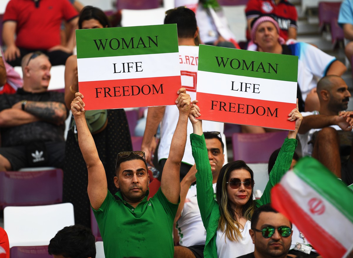 epa10317737 Fans of Iran hold signs reading 'Woman, Life, Freedom' prior to the FIFA World Cup 2022 group B soccer match between England and Iran at Khalifa International Stadium in Doha, Qa ...
