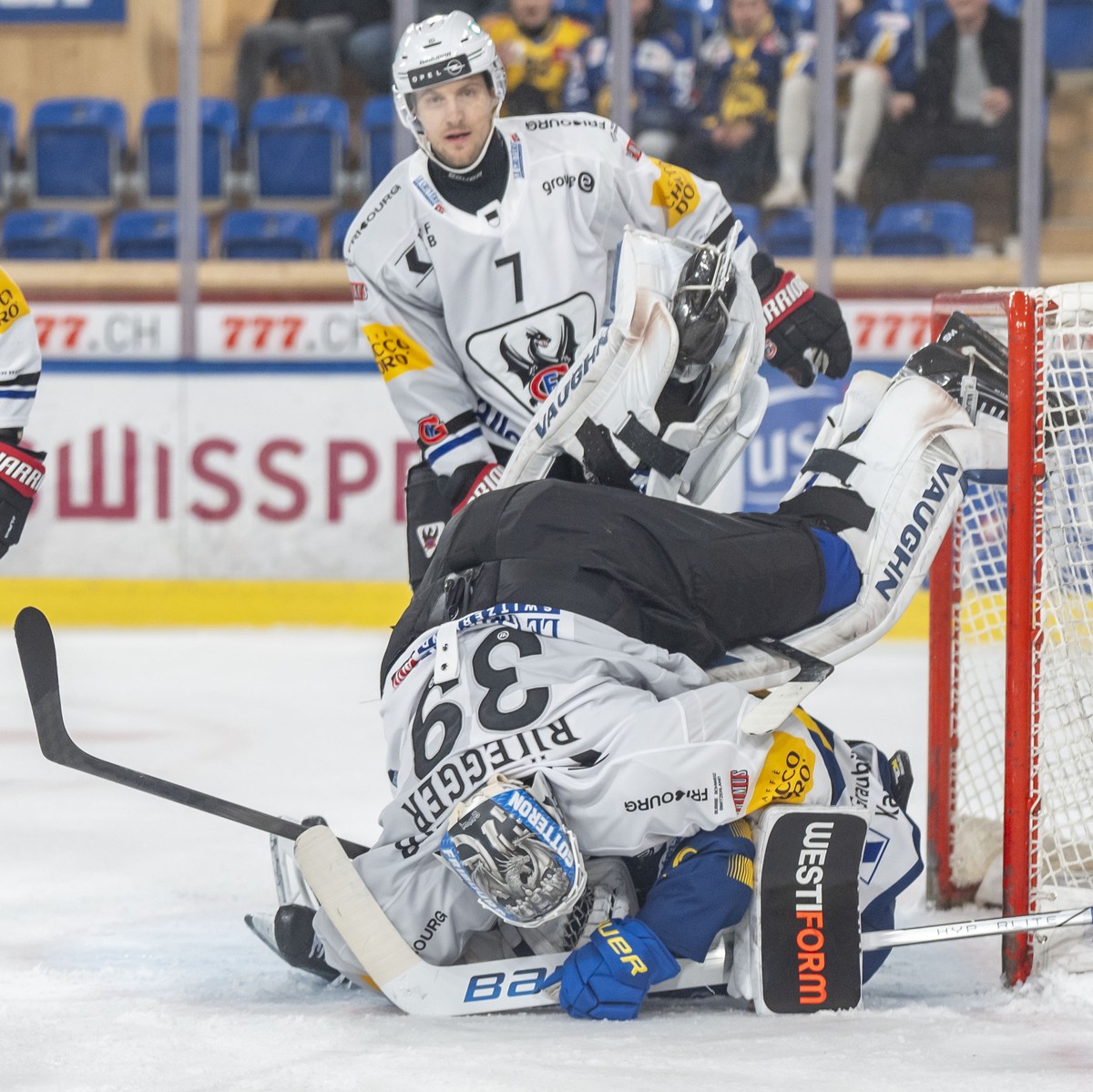 Torhueter Bryan Rueegger (HCFG) landet auf Filip Zadina (HCD) (darunter) dahinter Benoit Jecker (HCFG) und Ryan Gunderson (HCFG) (links) im Spiel der Eishockey National League zwischen dem HC Davos un ...