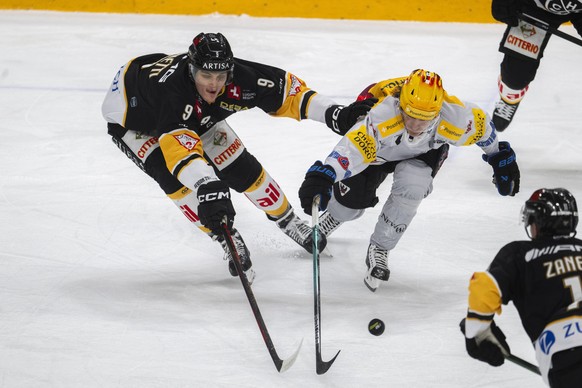 Brian Zanetti (HCL), left, fights for the puck with Marcus Soerensen (HCFG), right, during the regular season of National League Swiss Championship 2025/26 between HC Lugano and Fribourg Gotteron at t ...
