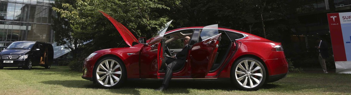 A visitor looks at a Tesla Model S electric car at the Motorexpo in Canary Wharf, London, June 13, 2014. Instead of a Ferrari Testarossa, the next "Wolf of Wall Street" could be driving a ze ...