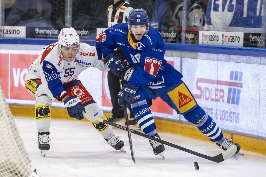 Klotens Max Lindroth, links, gegen Zugs Fabrice Herzog, rechts, im Spiel der Eishockey National League zwischen dem EV Zug und dem EHC Kloten am Mittwoch, 17. Dezember 2025 in der OYM Hall in Zug. (KE ...