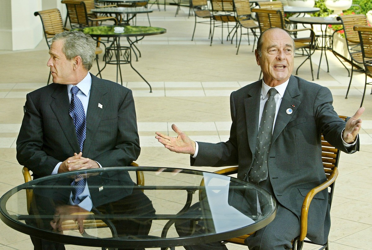 President Bush, left, glances left to find his interpreter as G8 Summit host, French President Jacques Chirac, begins speaking French as they meet near the end of the economic gathering in Evian, Fran ...