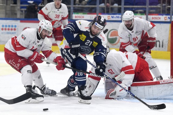 From left Lausanne&#039;s player Jason Fuchs, Ambri&#039;s player Brandon McMillan and Lausanne&#039;s goalkeeper Tobias Stephan, during the preliminary round game of National League 2021/22 between H ...