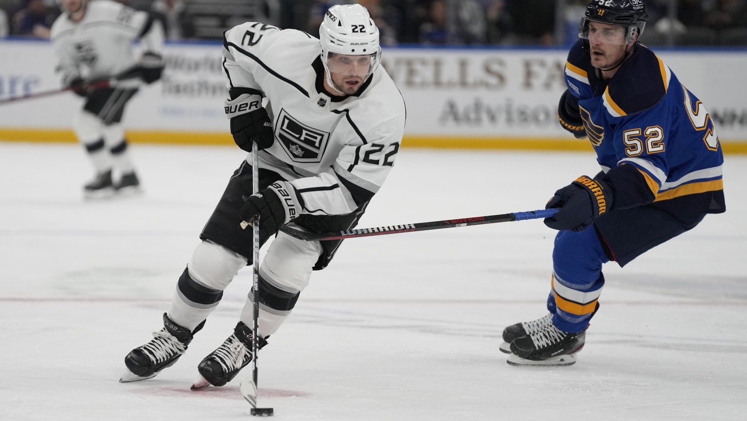 Los Angeles Kings&#039; Kevin Fiala (22) handles the puck as St. Louis Blues&#039; Noel Acciari (52) defends during the first period of an NHL hockey game Monday, Oct. 31, 2022, in St. Louis. (AP Phot ...