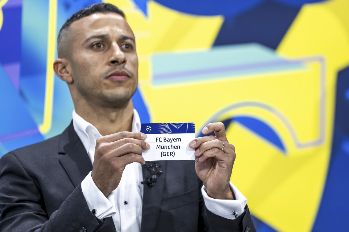 Spain's former player Thiago Alcantara shows a ticket of Bayern Munich during the UEFA Champions League knockout phase play-off draw, at the UEFA headquarters in Nyon, Switzerland, Friday, Jan. 3 ...