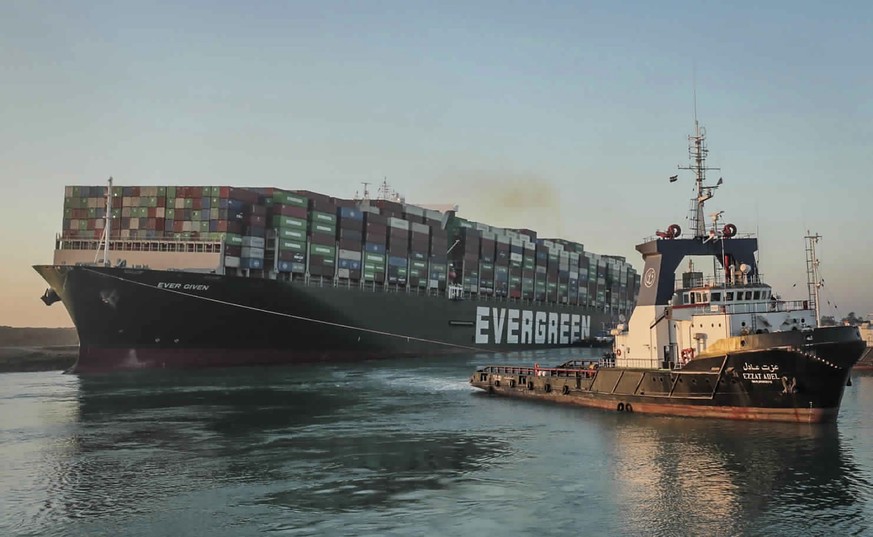 In this photo released by Suez Canal Authority, the Ever Given, a Panama-flagged cargo ship, is pulled by one of the Suez Canal tugboats, in the Suez Canal, Egypt, Monday, March 29, 2021. Engineers on ...