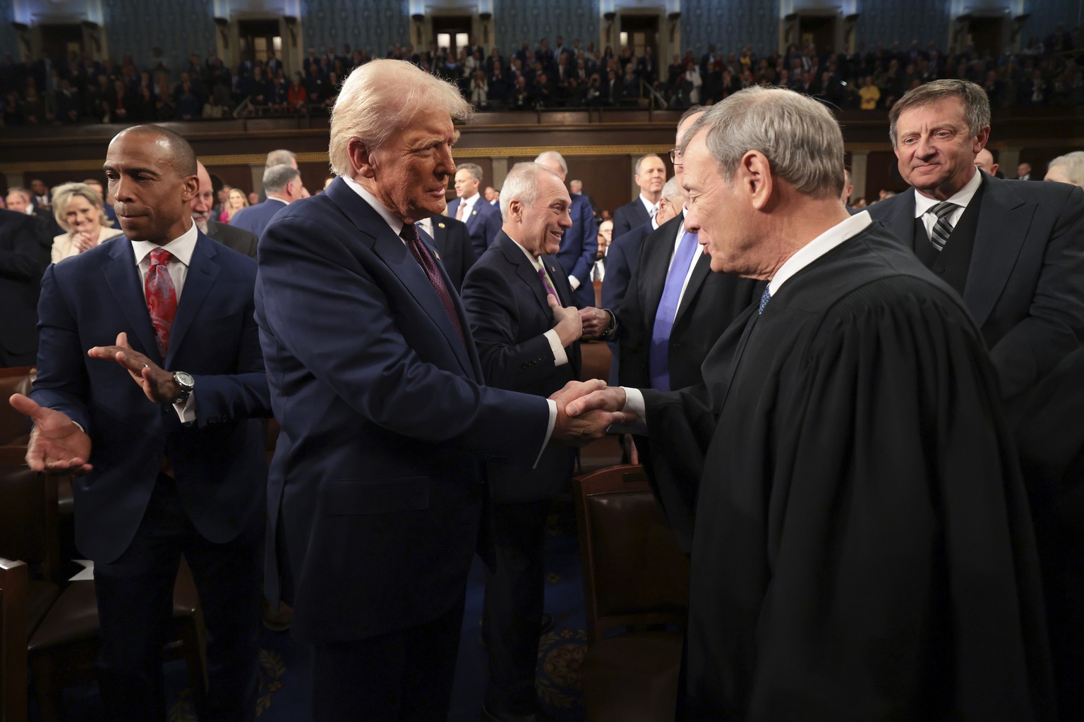 FILE - President Donald Trump, center, greets Chief Justice of the Supreme Court John Roberts, right, as he arrives to address a joint session of Congress at the Capitol in Washington, March 4, 2025.  ...