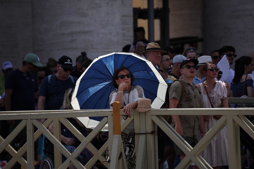 epa10749210 A woman protects herself from the sun with an umbrella in St. Peter&#039;s Square during Pope Francis&#039; Angelus prayer, Vatican City, 16 July 2023. EPA/MASSIMO PERCOSSI