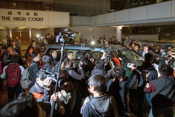 epa05799403 A scrum of photographers and cameramen surround the car carrying former Hong Kong chief executive Donald Tsang Yam-kuen as he leaves the High Court in Hong Kong, China, 17 February 2017. T ...