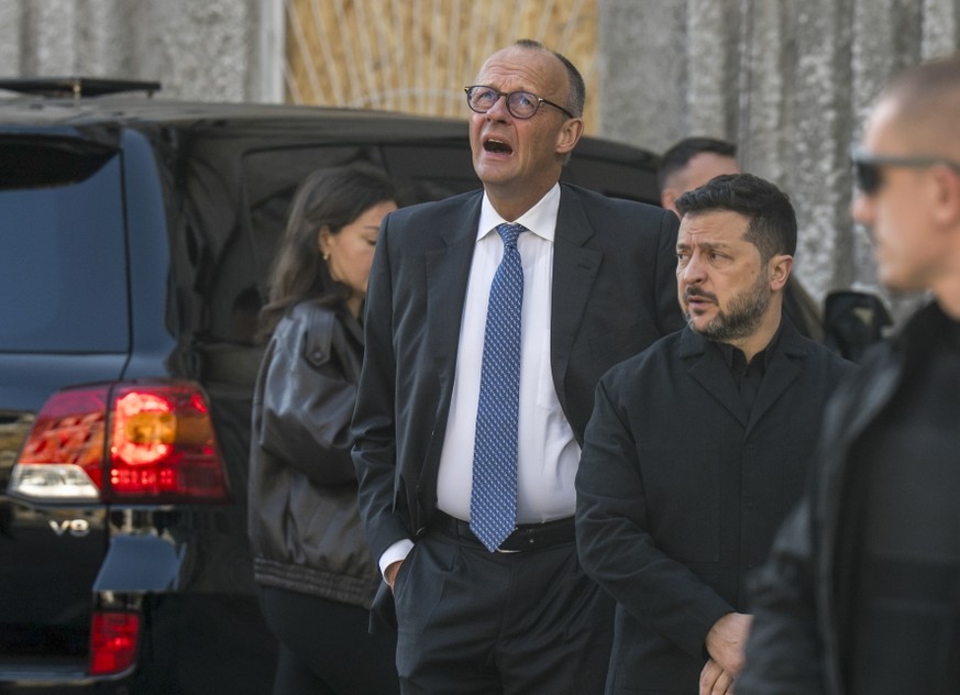 epa13280896 Germany's Chancellor Friedrich Merz (L) and Ukraine's President Volodymyr Zelensky (R) attend the site of a Russian strike on the building of the National Academy of Sciences on  ...