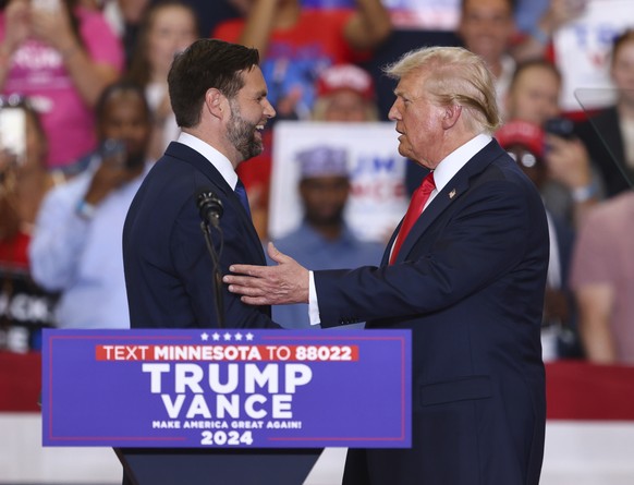 Republican presidential candidate former President Donald Trump and Republican vice presidential candidate Sen. JD Vance, R-Ohio, greet each other at a campaign rally, Saturday, July 27, 2024, in St.  ...