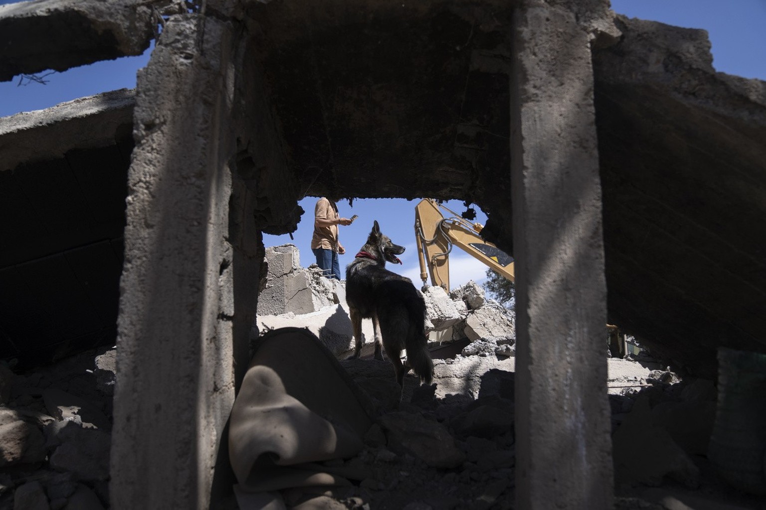 People and dogs dig through the rubble of a home that was damaged by an earthquake, in the village of Tafeghaghte, near Marrakech, Morocco, Monday, Sept. 11, 2023. Rescue crews expanded their efforts  ...