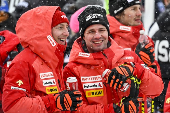 Justin Muroisisier of Switzerland reacts next to Beat Feuz of Switzerland in the finish area during the men&#039;s downhill race at the Alpine Skiing FIS Ski World Cup in Kitzbuehel, Austria, Saturday ...