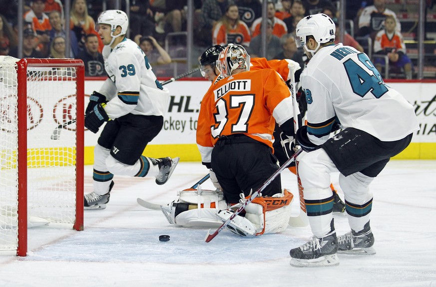 The puck bounces back out of the net behind Philadelphia Flyers goalie Brian Elliott after San Jose Shark&#039;s Logan Couture (39) left, scored during an NHL hockey game, Tuesday, Oct. 9, 2018, in Ph ...