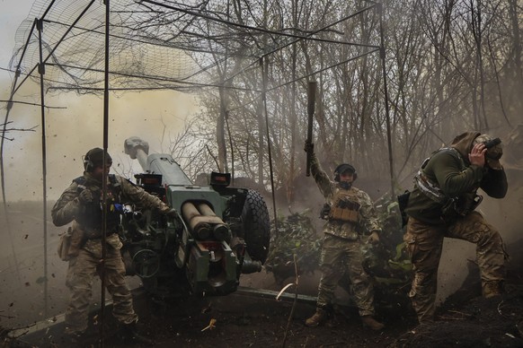 FILE - Ukrainian soldiers fire a howitzer D-30 at the frontline near Bakhmut, Donetsk region, Ukraine, Wednesday, April 19, 2023. Ukrainian President Volodymyr Zelenskyy said Sunday, May 21, 2023 that ...