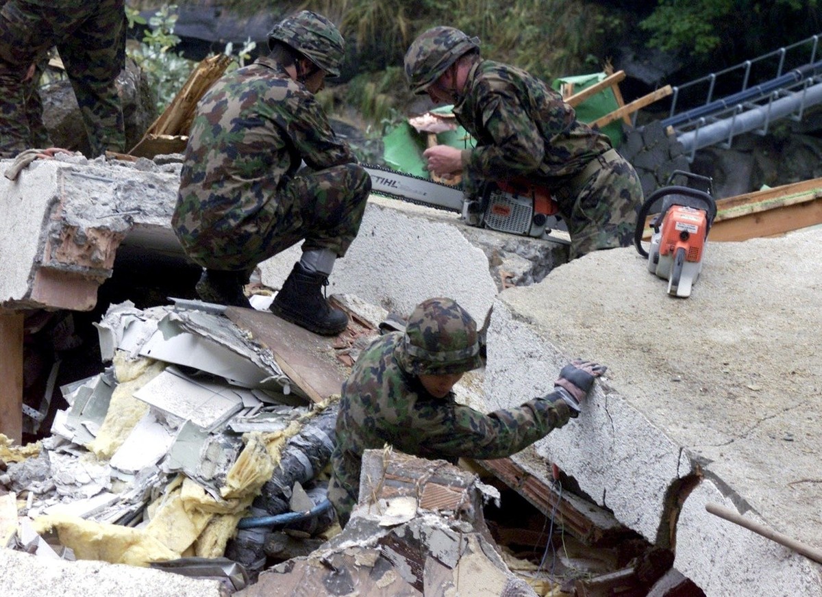 Armee-Angehoerige bei der Arbeit am Dienstag, 17. Oktober 2000 in Gondo. Die Rettungsarbeiten sind nach der Katastrophe vom Samstag, bei dem das Walliser Dorf Gondo von einer Gesteinslawine zerstoert  ...