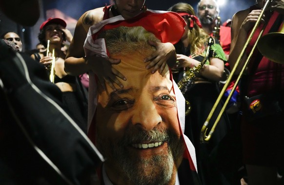 A supporter of former Brazilian President Luiz Inacio Lula da Silva holds a flag emblazoned with da Silva&#039;s face after results in the presidential run-off election were announced, in Sao Paulo, B ...