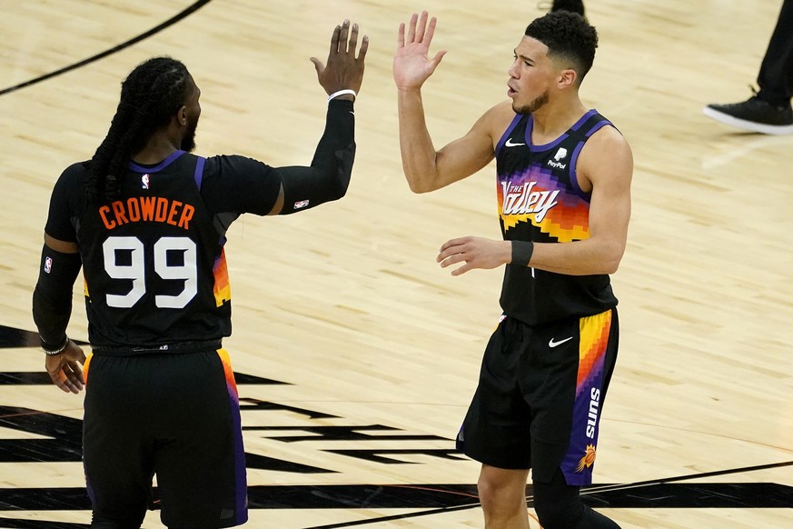 Phoenix Suns guard Devin Booker high fives teammate Jae Crowder (99) during the first half of an NBA basketball game against the Utah Jazz, Wednesday, April 7, 2021, in Phoenix. (AP Photo/Matt York)