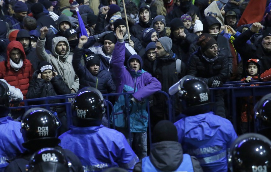 epa05765504 People shout anti-government slogans as they face riot police during a protest rally in front of government headquarters in Bucharest, Romania, 01 February 2017. Up to 100,000 people gathe ...