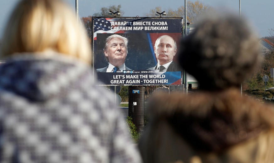 FILE PHOTO: A billboard showing a pictures of US president-elect Donald Trump and Russian President Vladimir Putin is seen through pedestrians in Danilovgrad, Montenegro, November 16, 2016. REUTERS/St ...