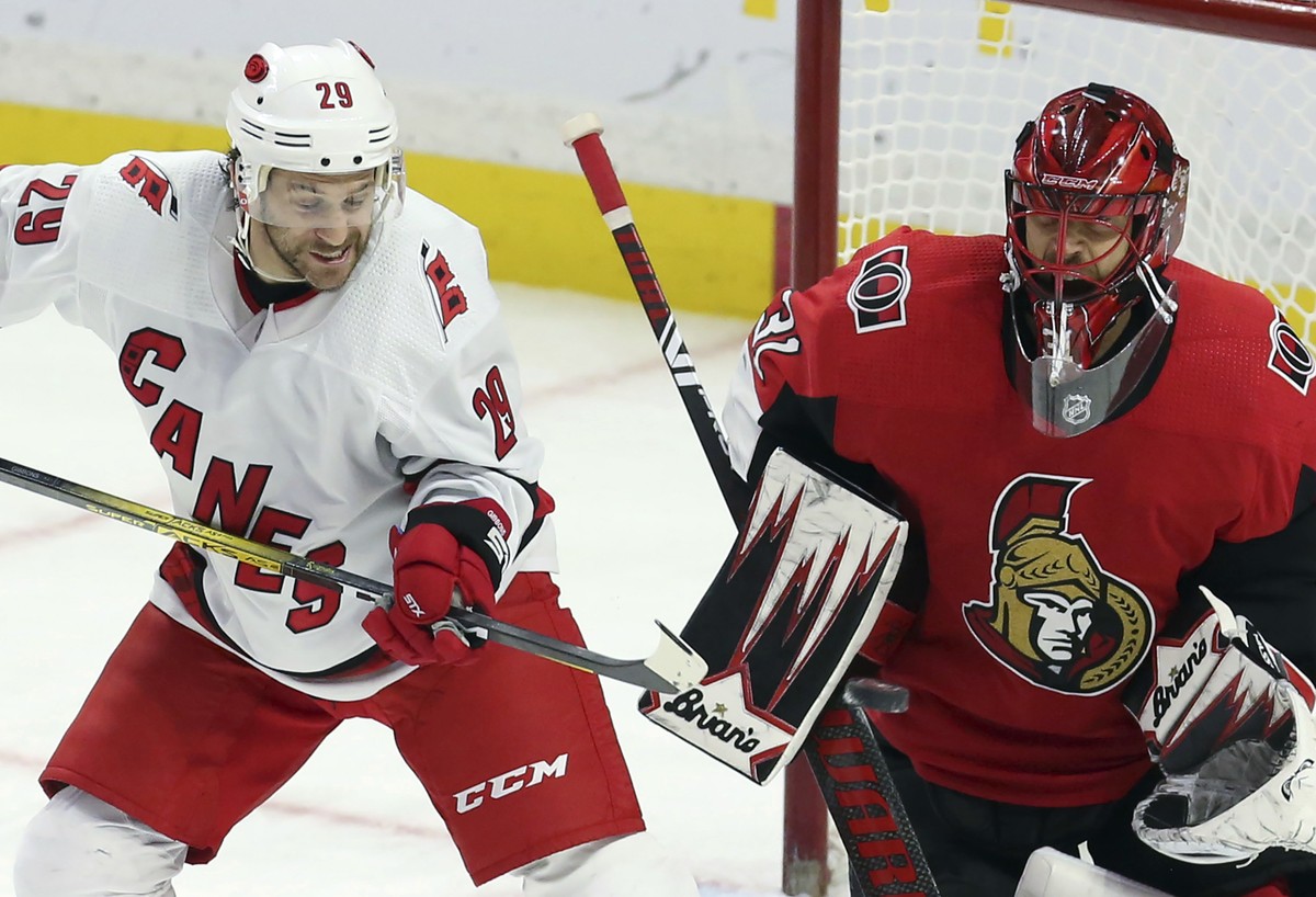 Carolina Hurricanes' Brian Gibbons (29) attempts to deflect the puck next to Ottawa Senator goaltender Anders Nilsson during the third period of an NHL hockey game in Ottawa, Ontario, Saturday, N ...
