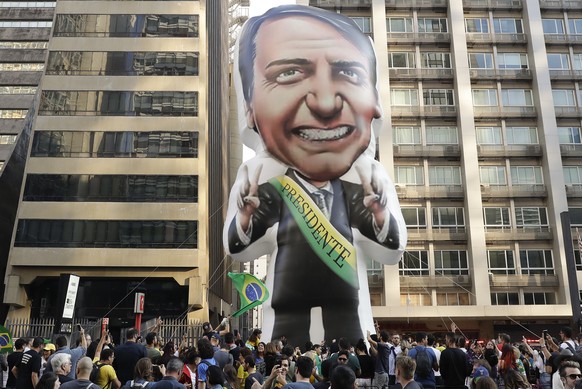 FILE - In this Sept. 9, 2018 file photo, supporters of presidential frontrunner Jair Bolsonaro, exhibit a large, inflatable doll in his image as they march along Paulista Avenue to show support for hi ...