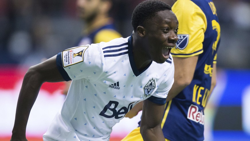 FILE - In this March 2, 2017, file photo, Vancouver Whitecaps&#039; Alphonso Davies, front, celebrates after scoring a goal as New York Red Bulls&#039; Aaron Long looks away during the first half of a ...