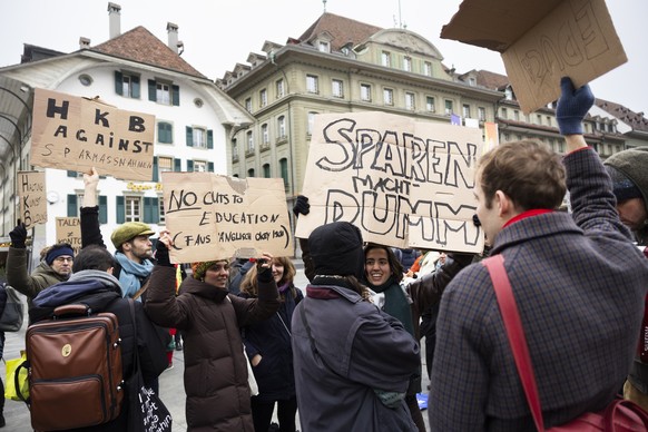 Demonstranten halten Plakate mit den Aufschriften &quot;Sparen macht dumm&quot;, &quot;HKB against Sparmassnahmen&quot; und &quot;No cuts to education&quot; bei einer Kundgebung der Kommunistischen Ju ...