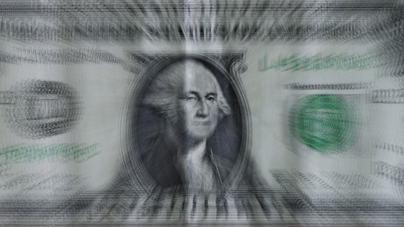 This long exposure, zoomed photo shows a U.S. one dollar bill Monday, May 30, 2022, in Salt Lake City. Rising energy prices have been feeding inflation, which is already at its highest levels in four  ...