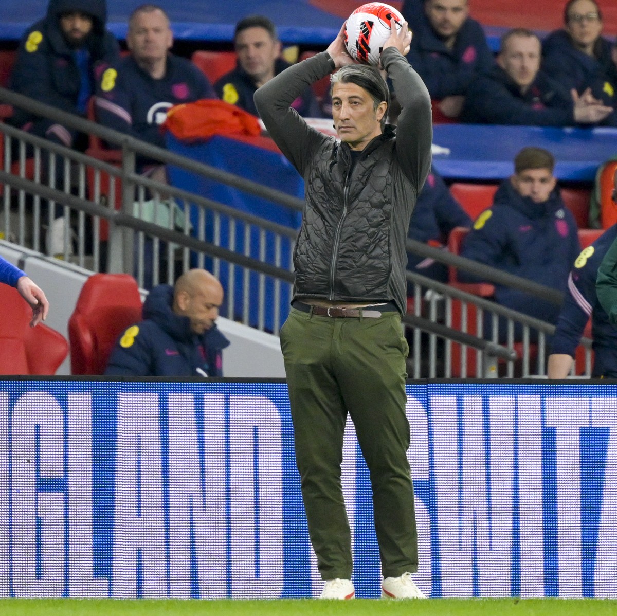 England's forward Jack Grealish, left, and Switzerland's head coach Murat Yakin, right, during a friendly soccer match between England and Switzerland, at the Wembley Stadium in London, Engl ...