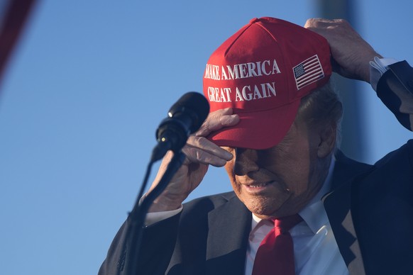 Republican presidential nominee former President Donald Trump puts on a campaign hat as he speaks at a campaign rally at the Calhoun Ranch, Saturday, Oct. 12, 2024, in Coachella, Calif. (AP Photo/Alex ...